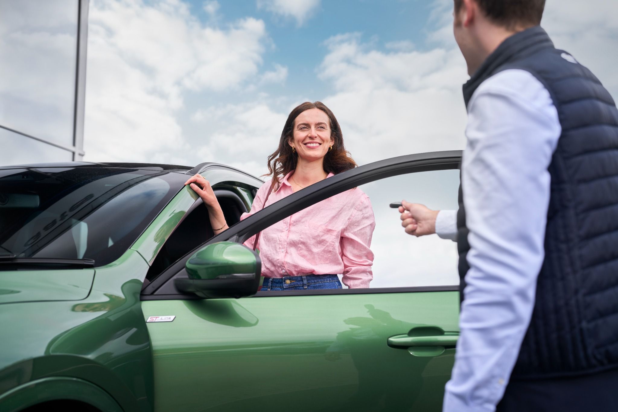 Ford salesperson giving a key of a courtesy car to a customer