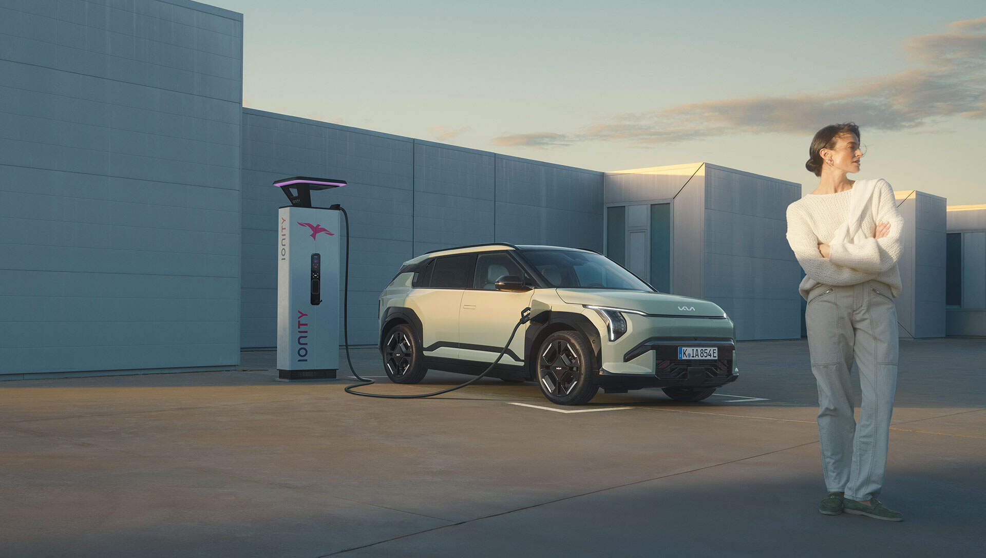 The new Kia EV3 lifestyle image with person stood next to the car