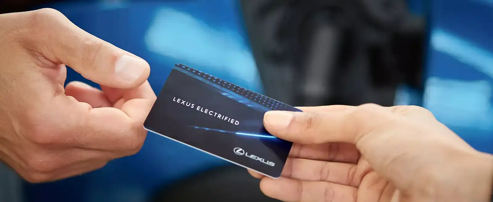 close up of a lexus electrified card passing between two people