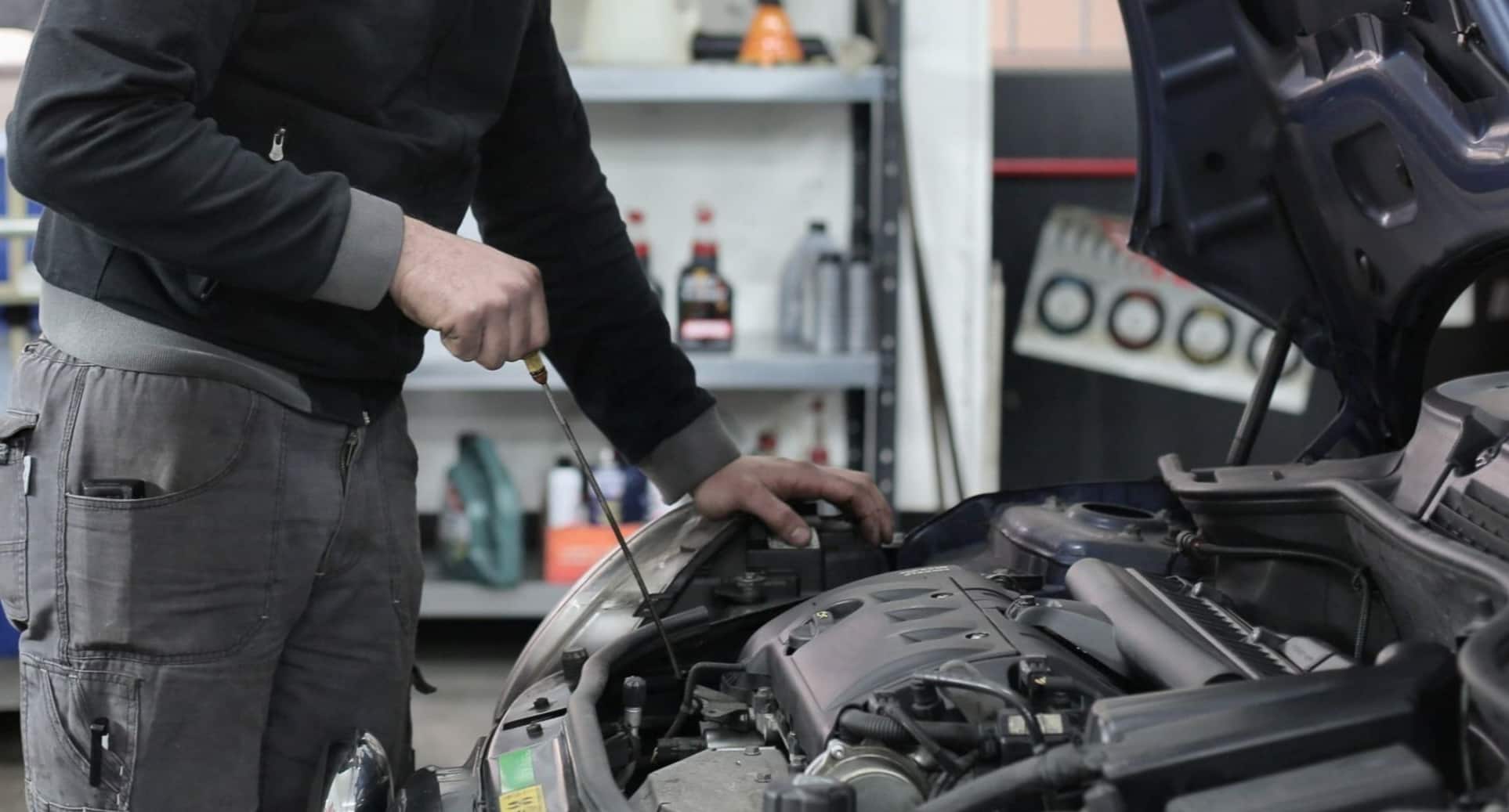 Man working under bonnet of car