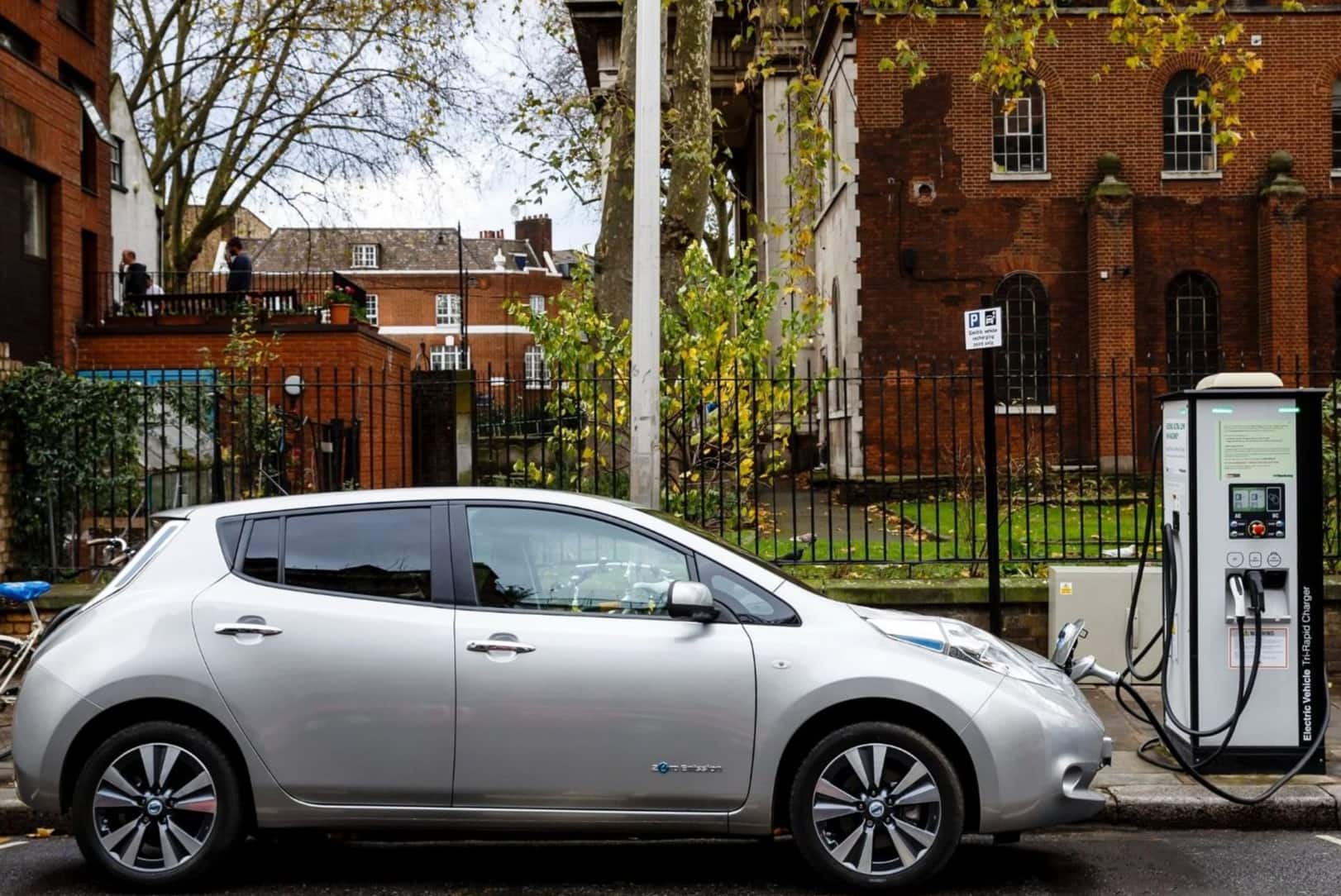 Silver car charging at the side of the road
