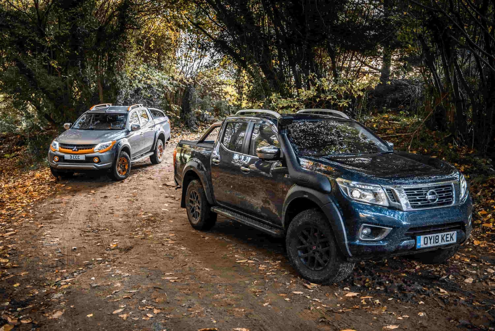 Mitsubishi L200 Barbarian SVP II and Nissan Navara AT32 parked in woods
