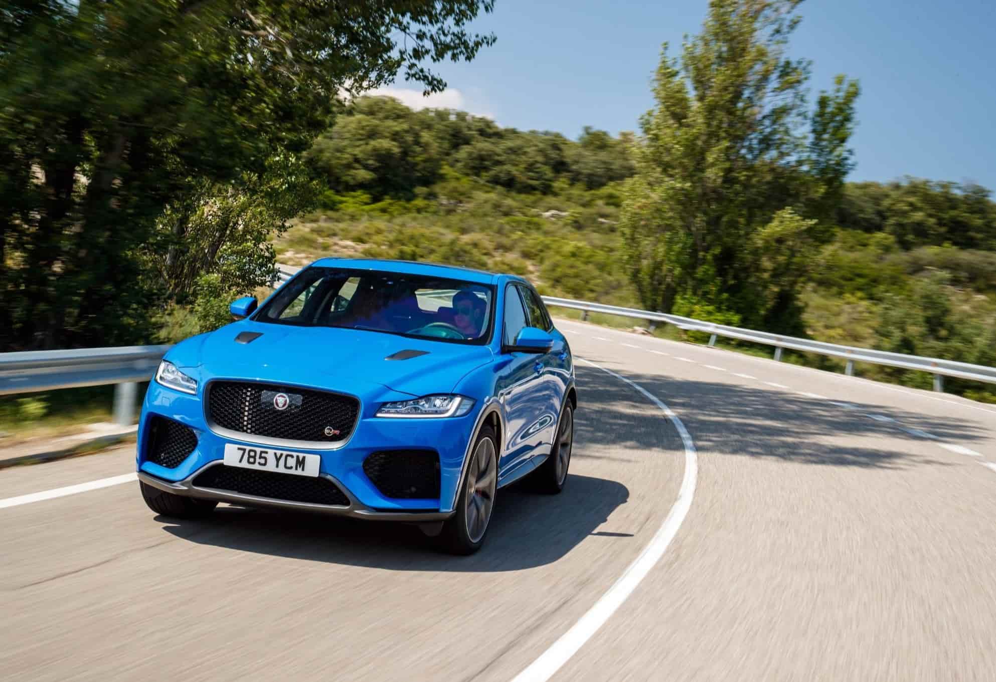 Blue Jaguar F-Pace driving down road