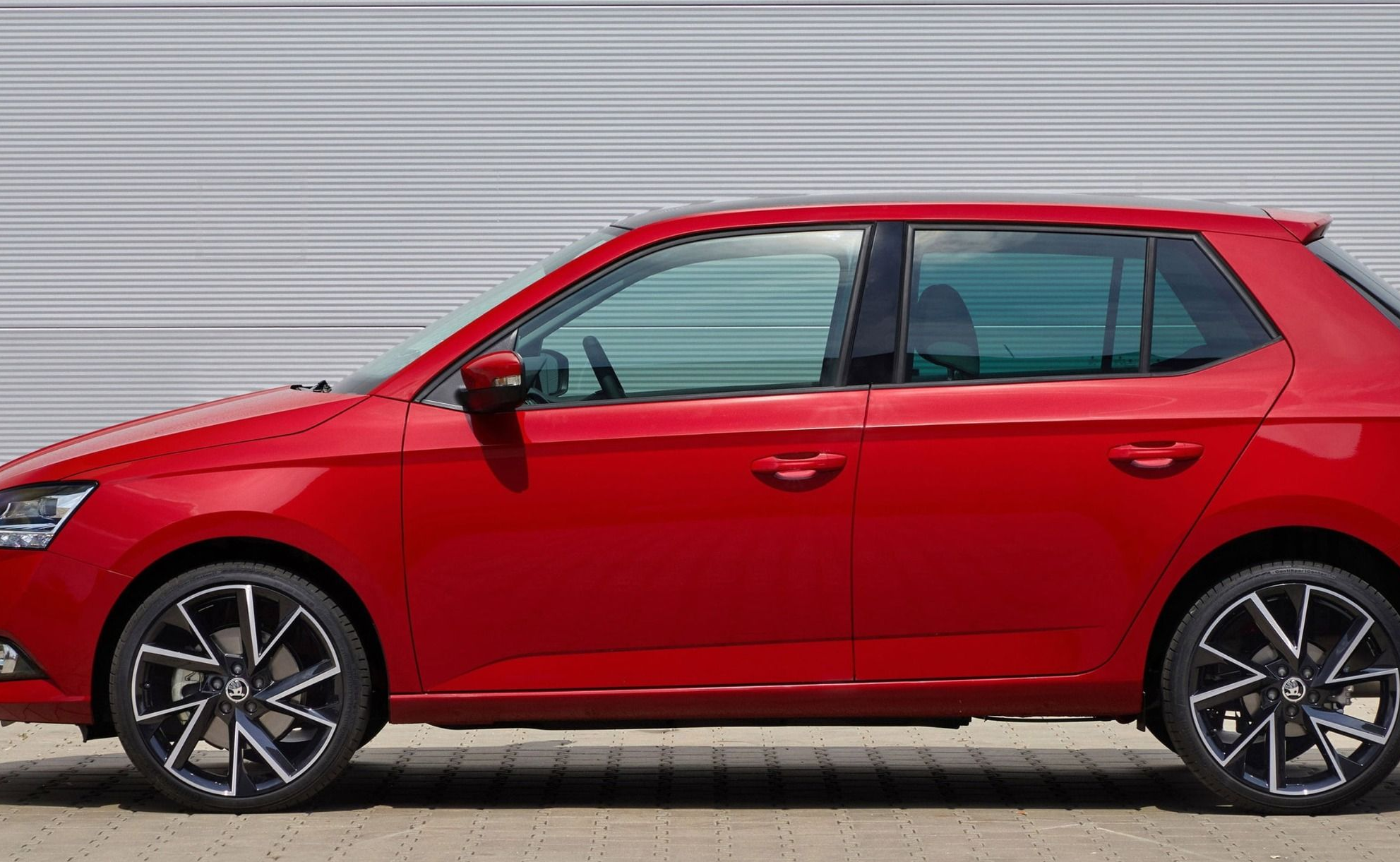 Side view of a red Skoda Fabia parked