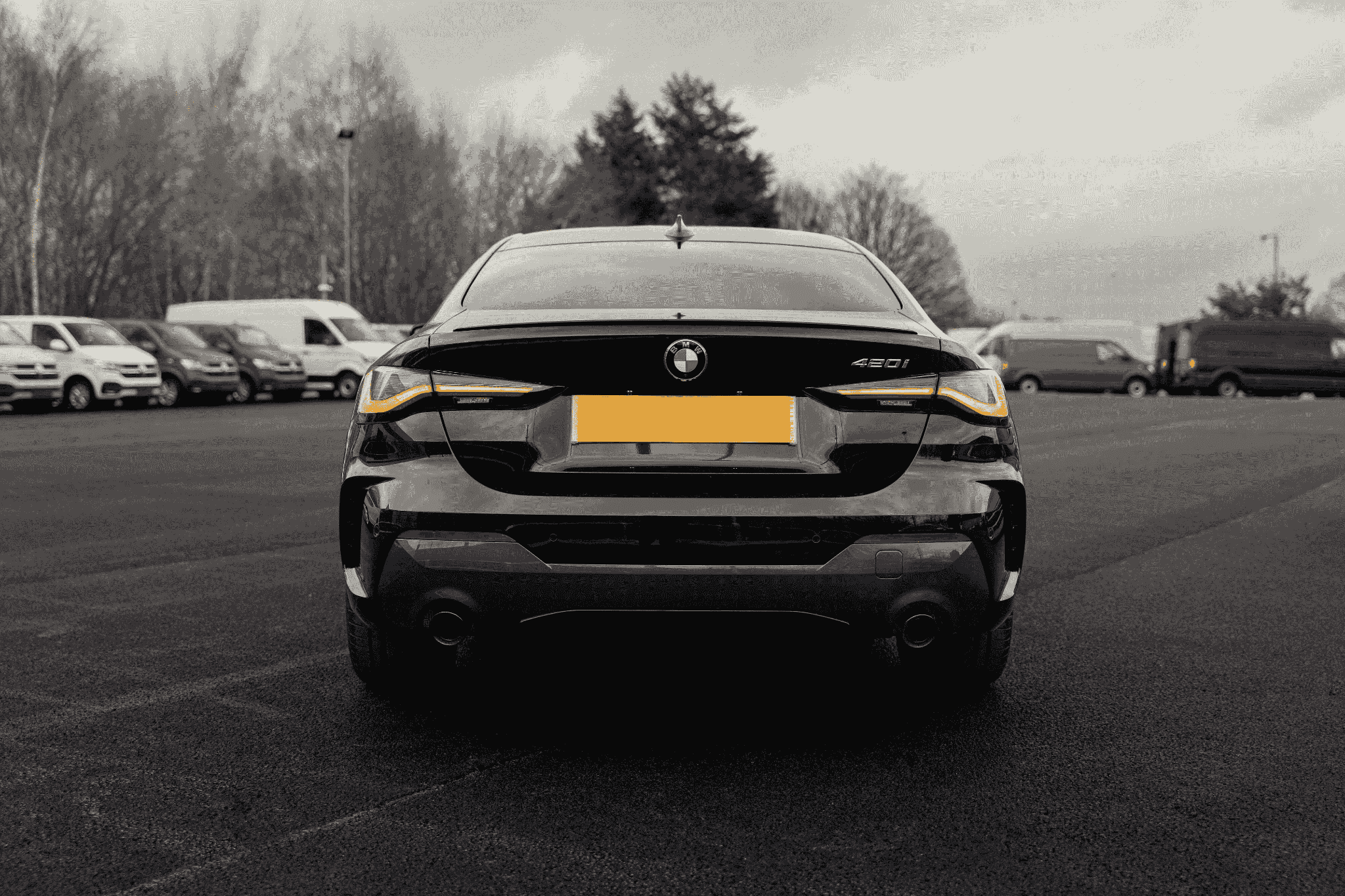 black bmw 4 series car rear on a carpark