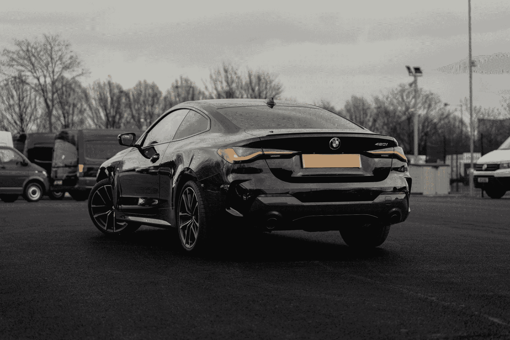 black bmw 4 series car rear side on a carpark