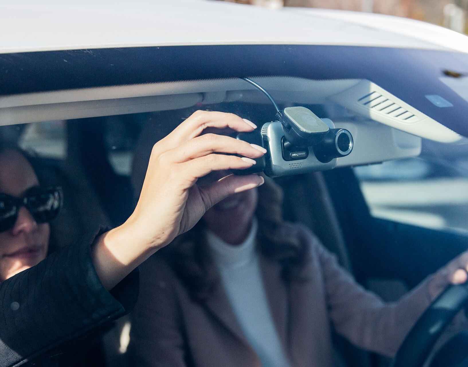 looking through a car windscreen with a couple checking a dashcam