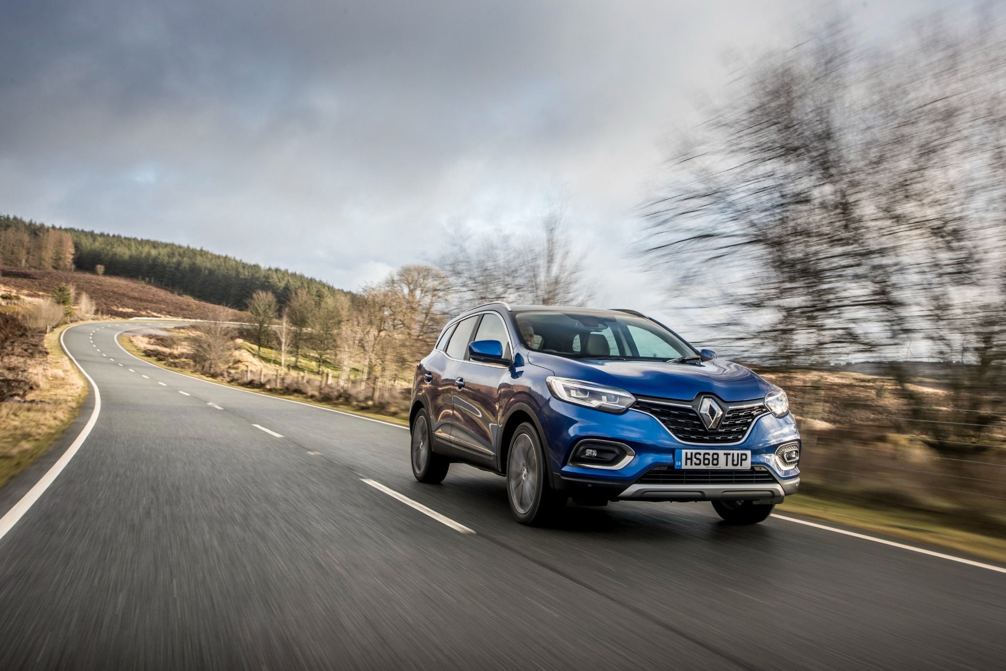 Blue Renault Kadjar driving down the road