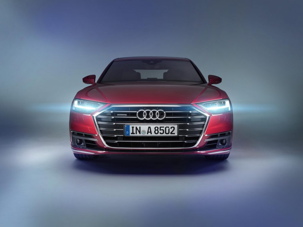 Red Audi with headlights on