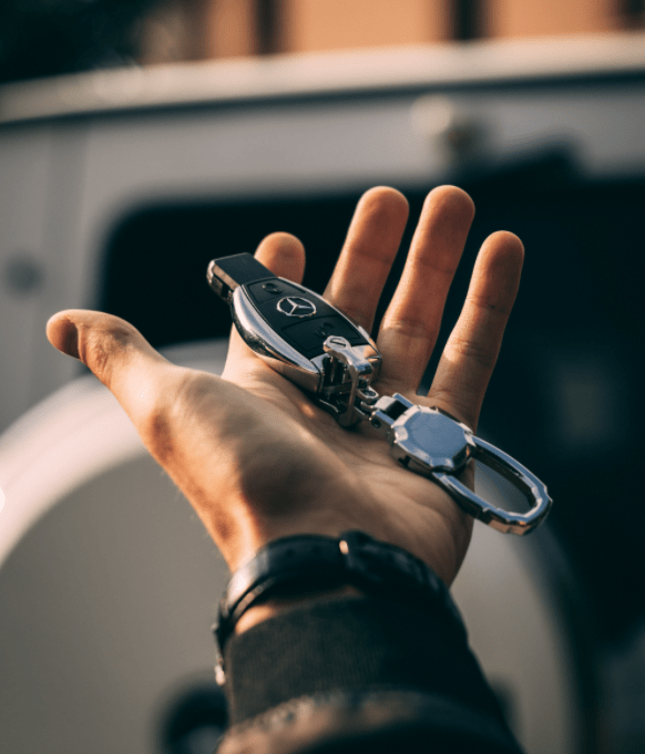 Person holding mercedes-benz car keys