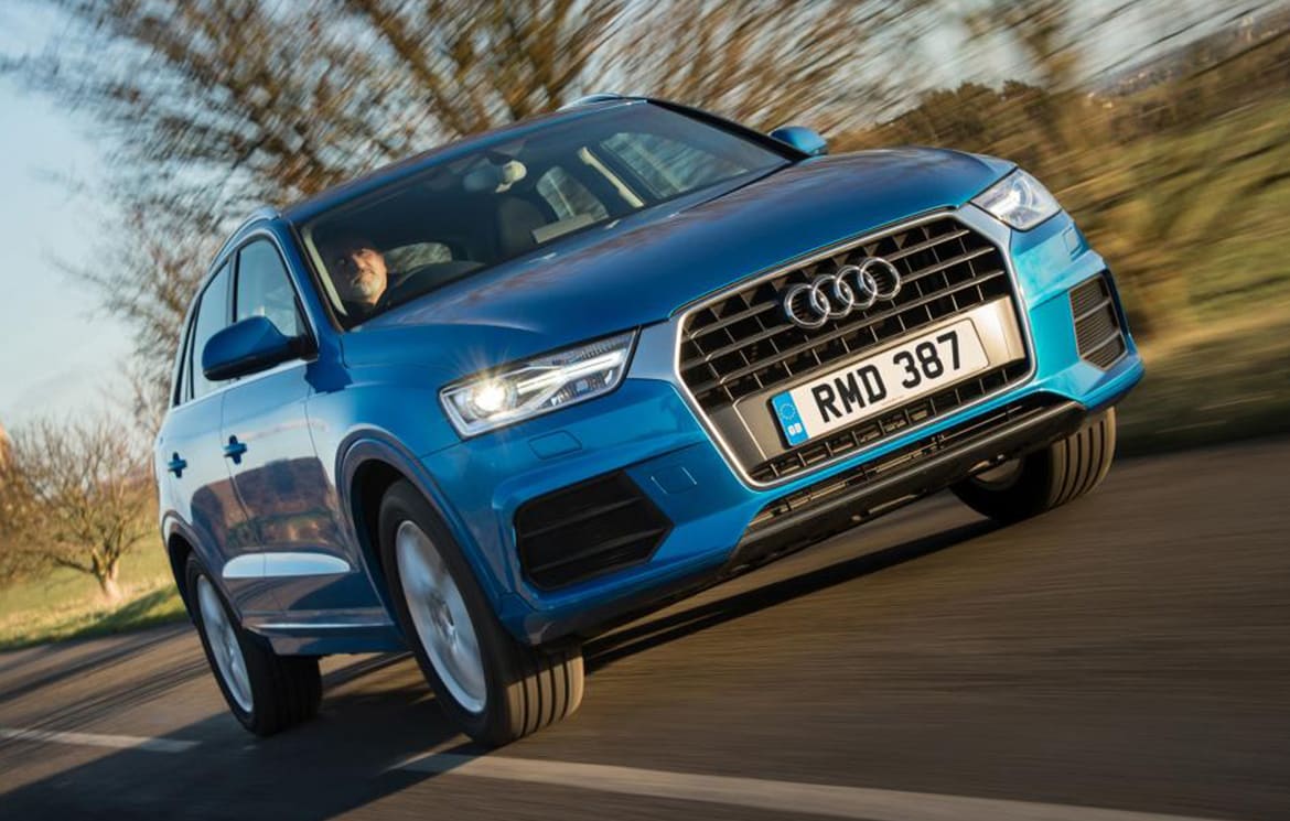 blue audi q3 driving along a road
