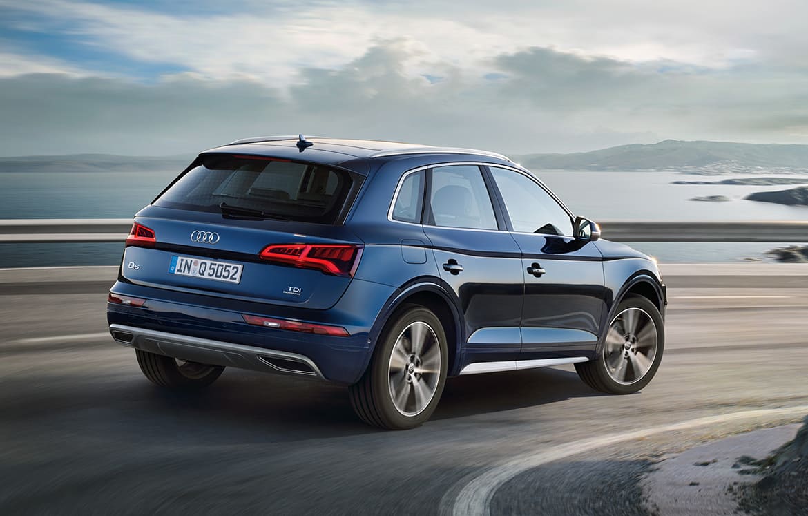 back side view of blue audi q5 driving overlooking the water