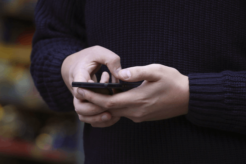 Man Holding His Phone to Contact Car Seller