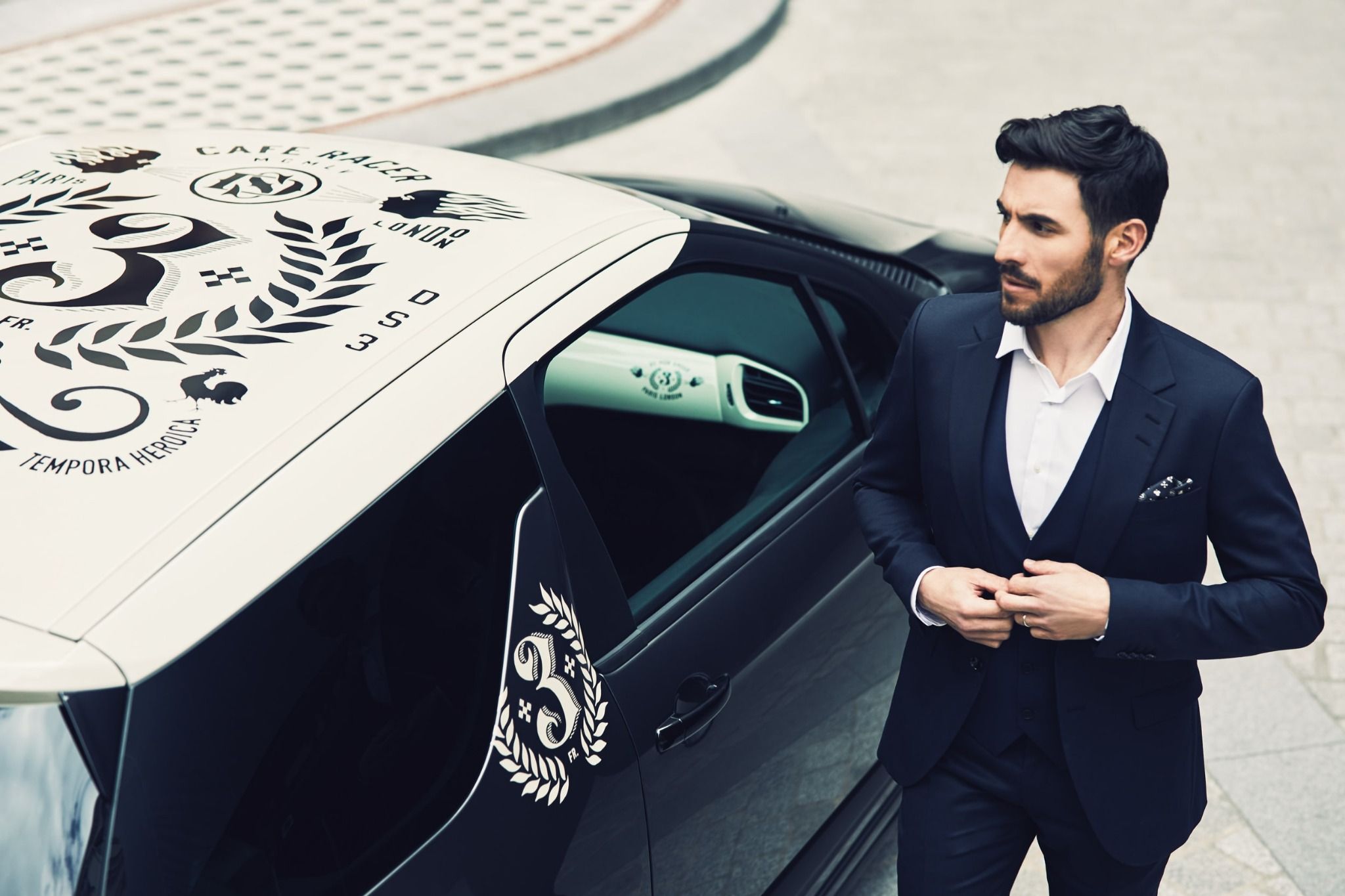 man in suit standing next to ds3 cafe racer car with detailed roof