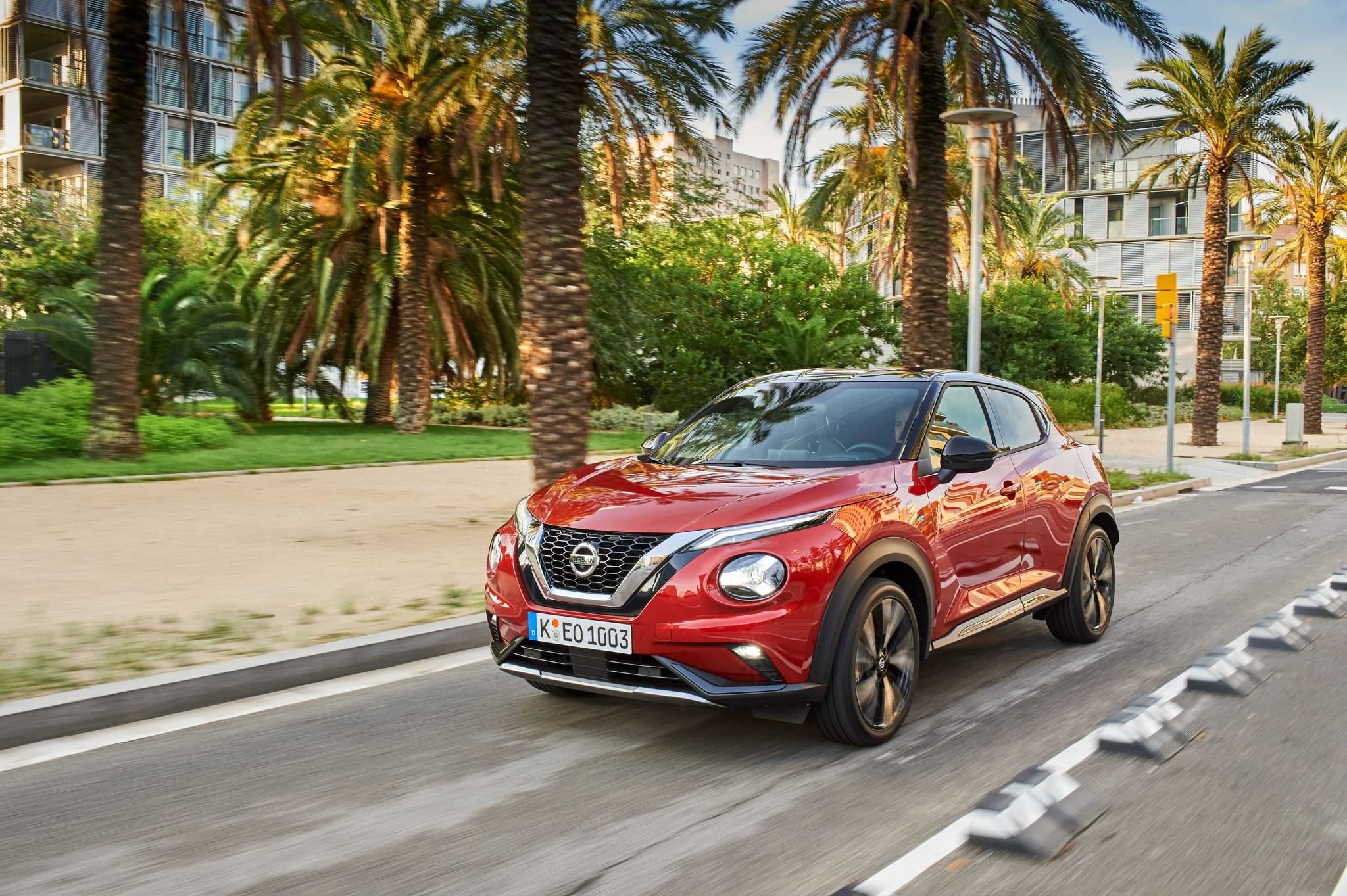 Red Nissan Juke Driving Down the Road