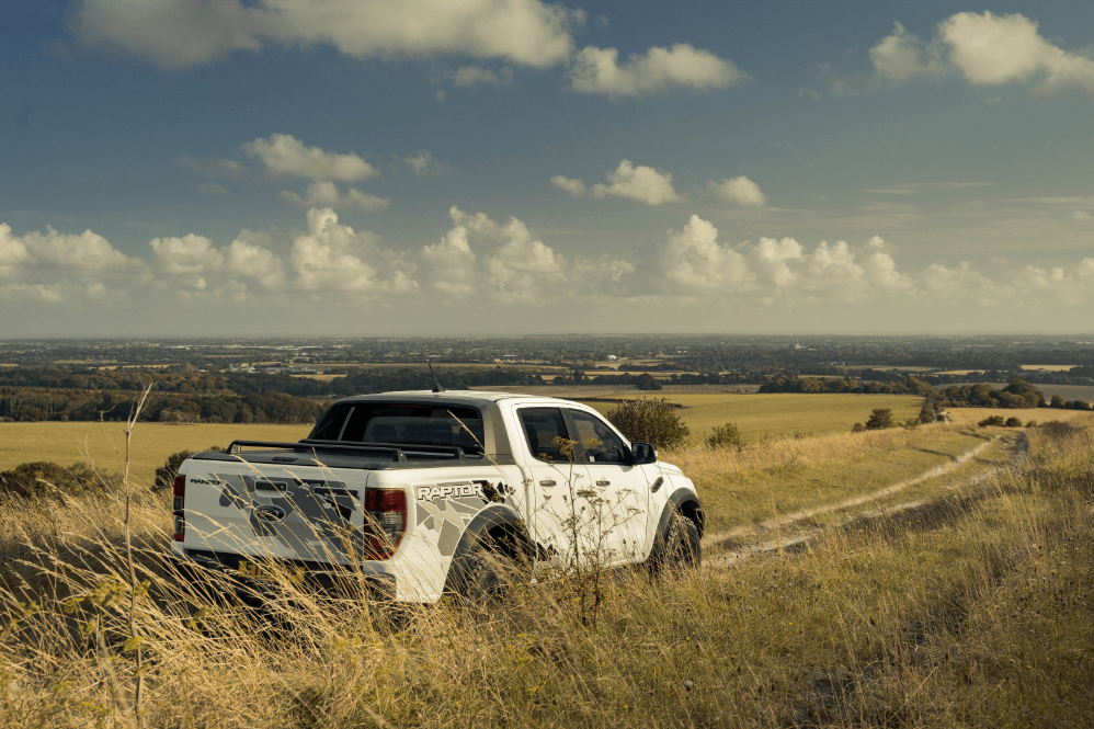 rera view of ford ranger raptor driving through countryside