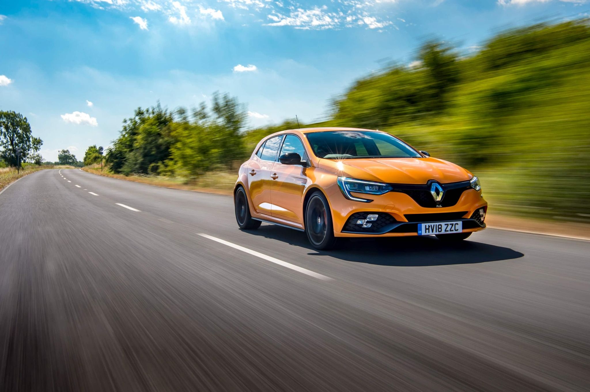 Orange Renault Driving Down the Road Fast