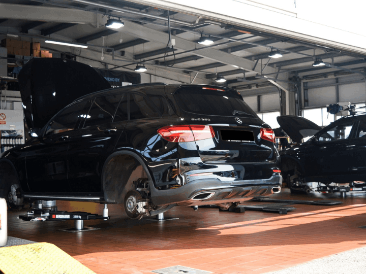 Black car in the workshop having an MOT