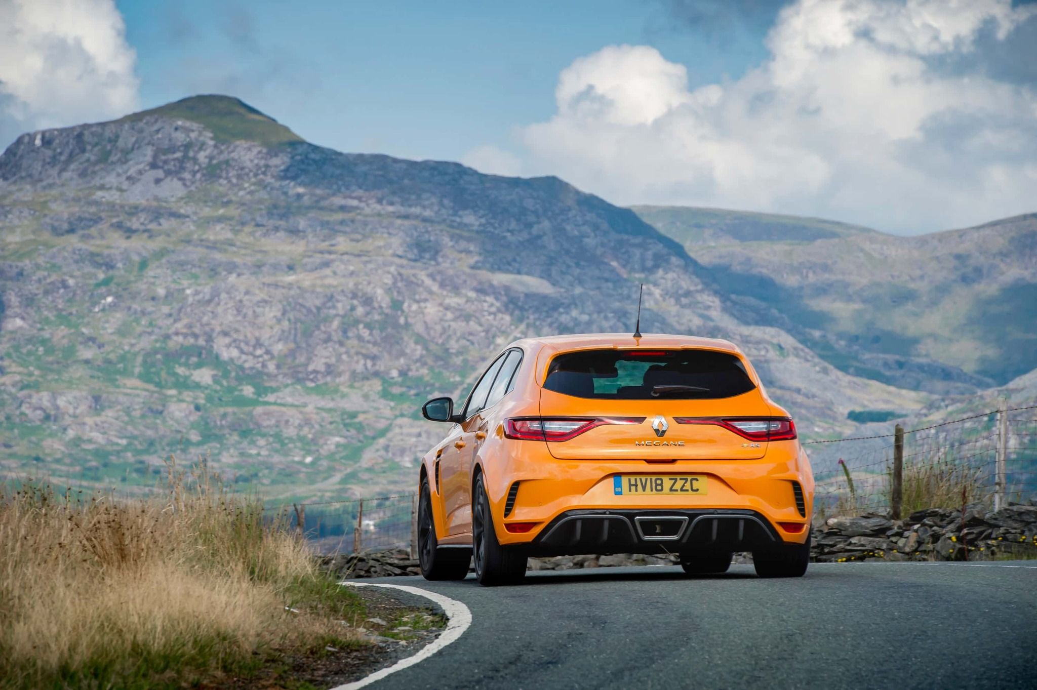rear view of a Orange Renault Megane RS parked on a road