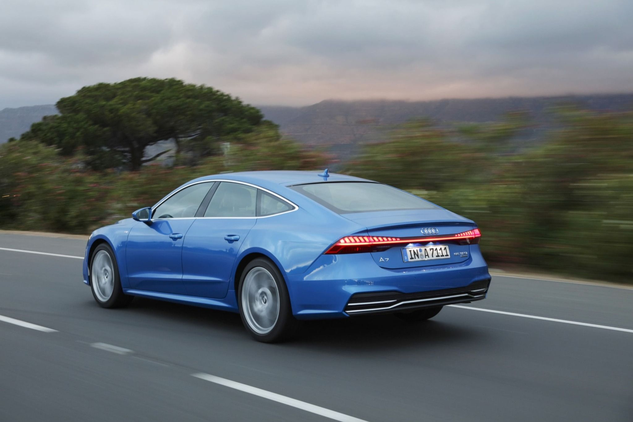 rear view of blue audi a7 sportback driving on a road