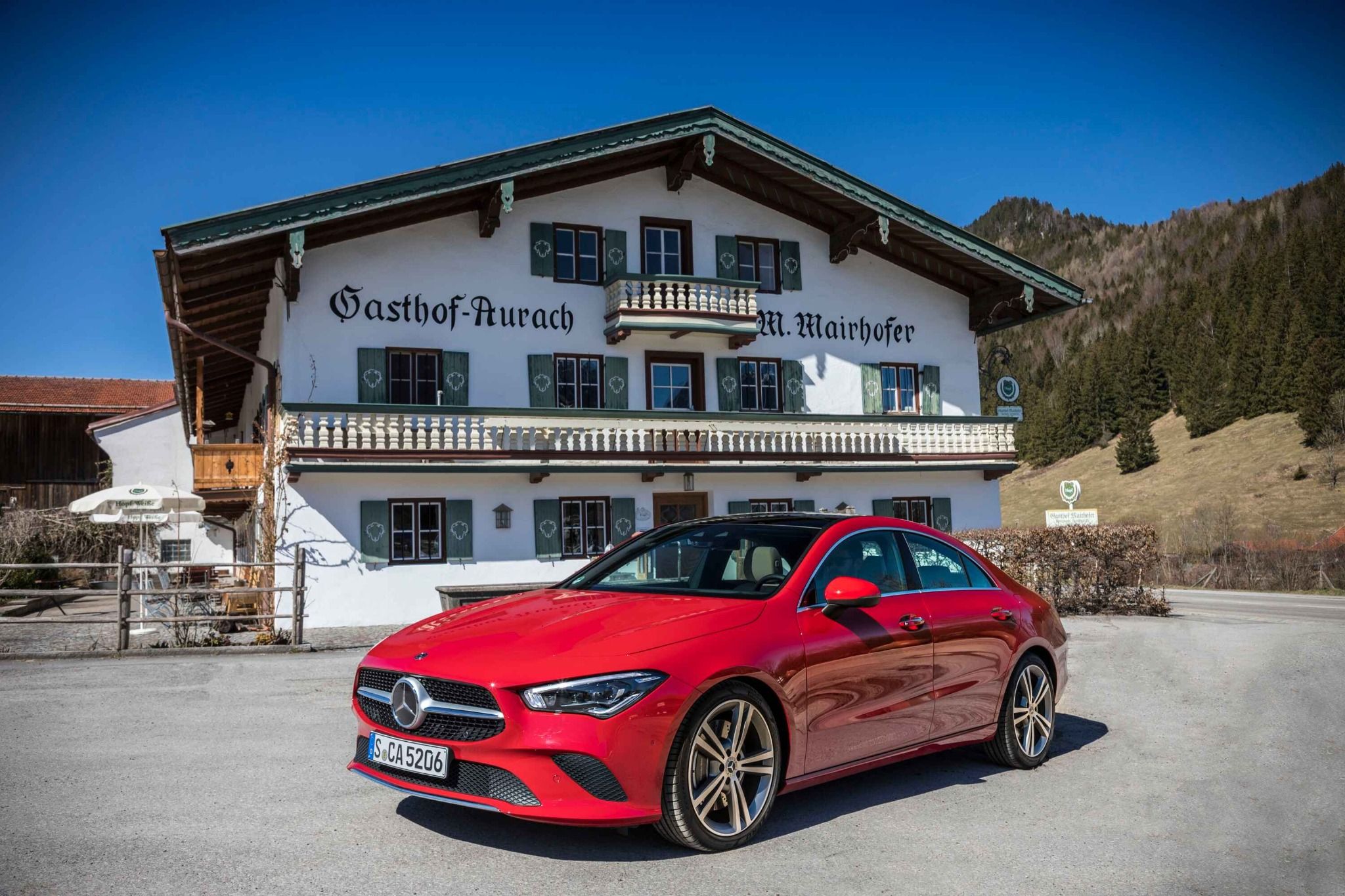 Red Mercedes CLA parked up in front of a building
