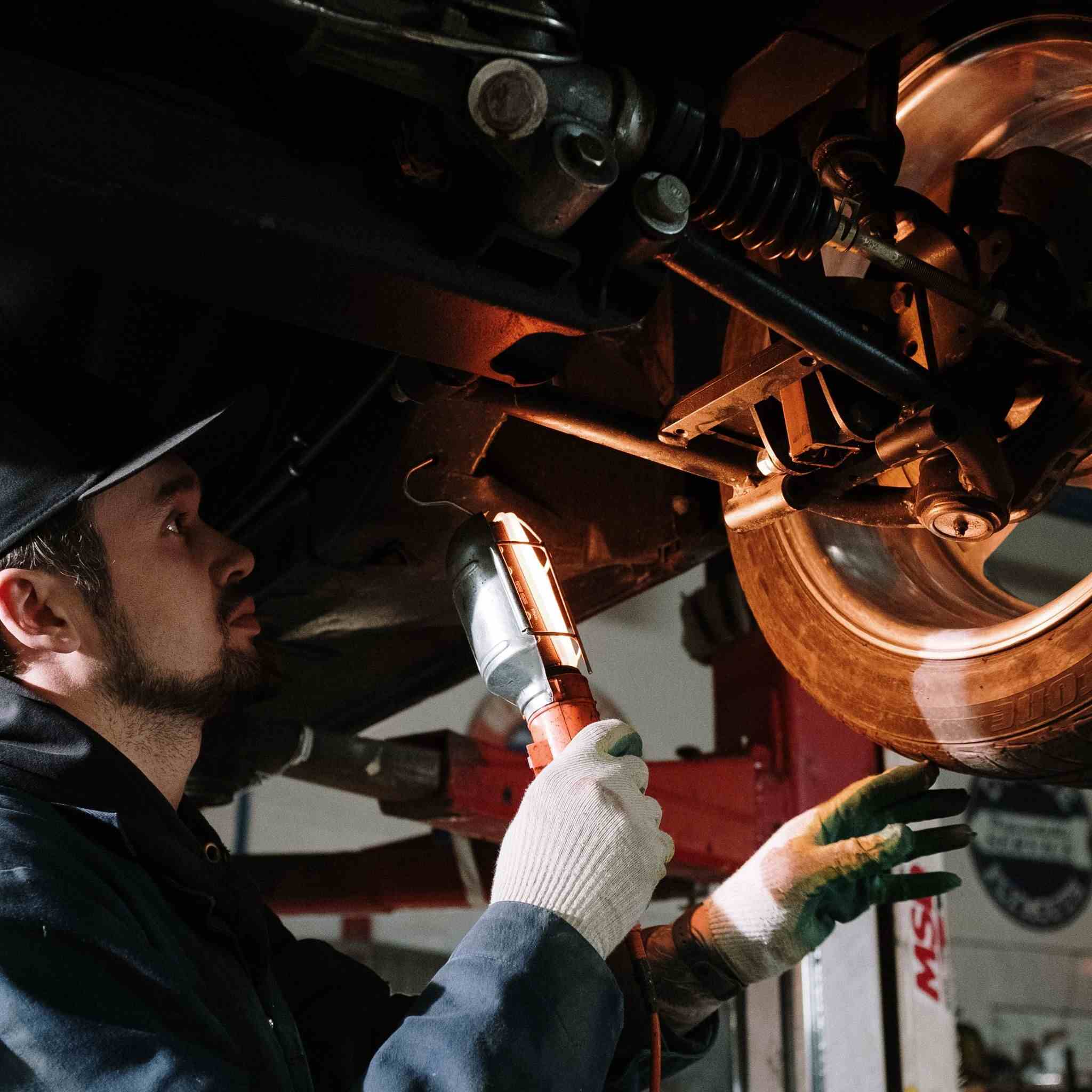 Technician looking underneath a car