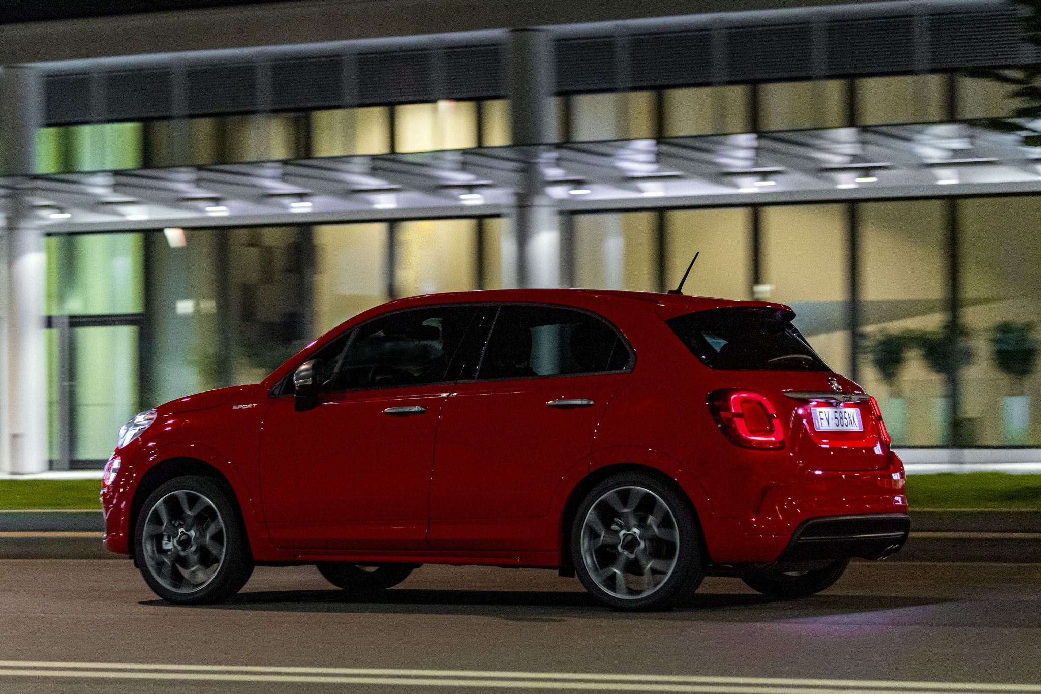 Side view of red Fiat 500x Sport driving on a road
