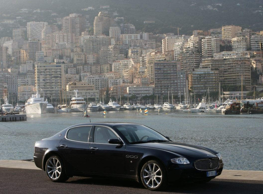 Black Maserati Quattroporte parked next to water