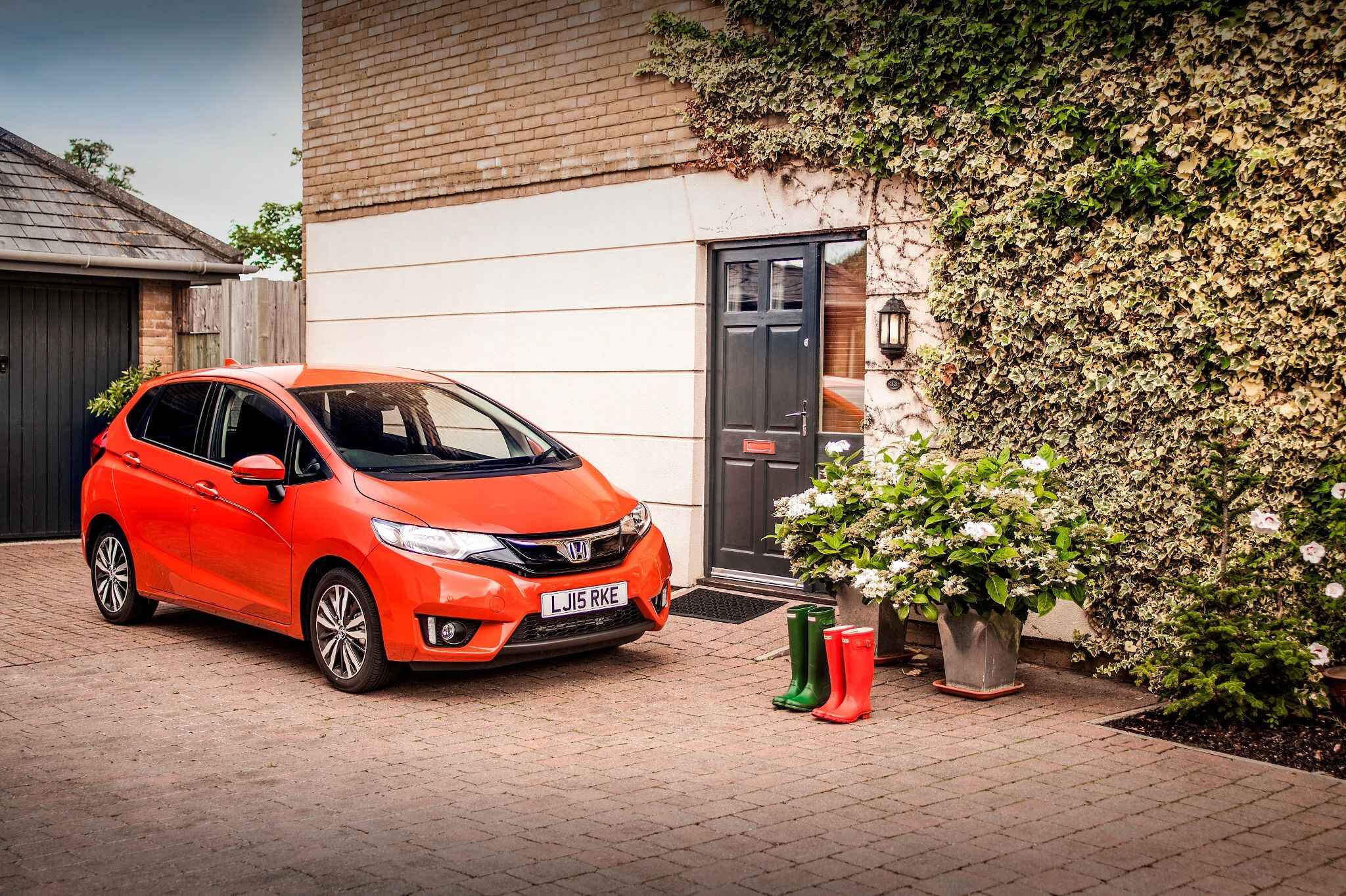 Orange Honda Jazz Parked in Front of Building