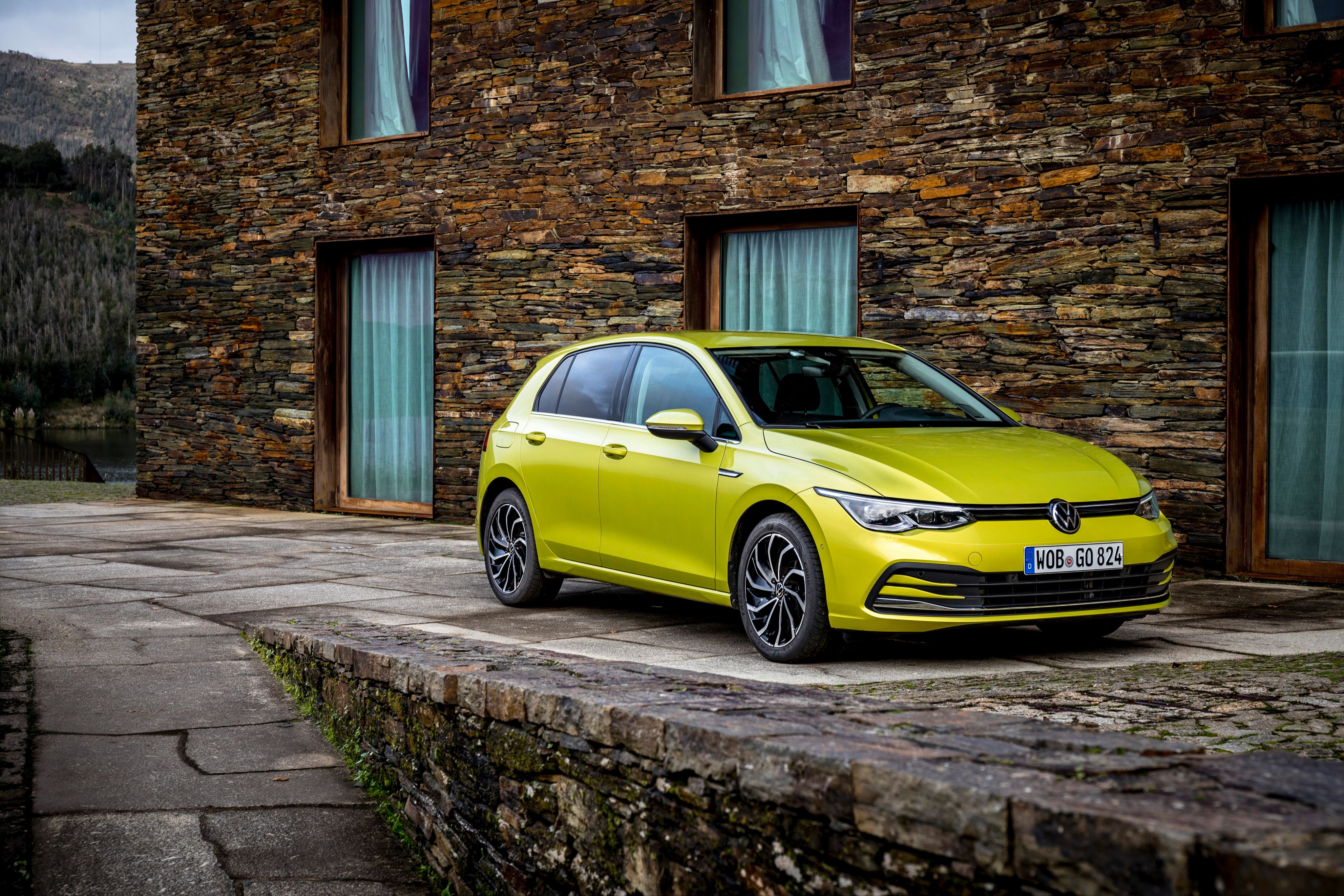 Yellow VW Golf Parked Up Next to a Brick Building