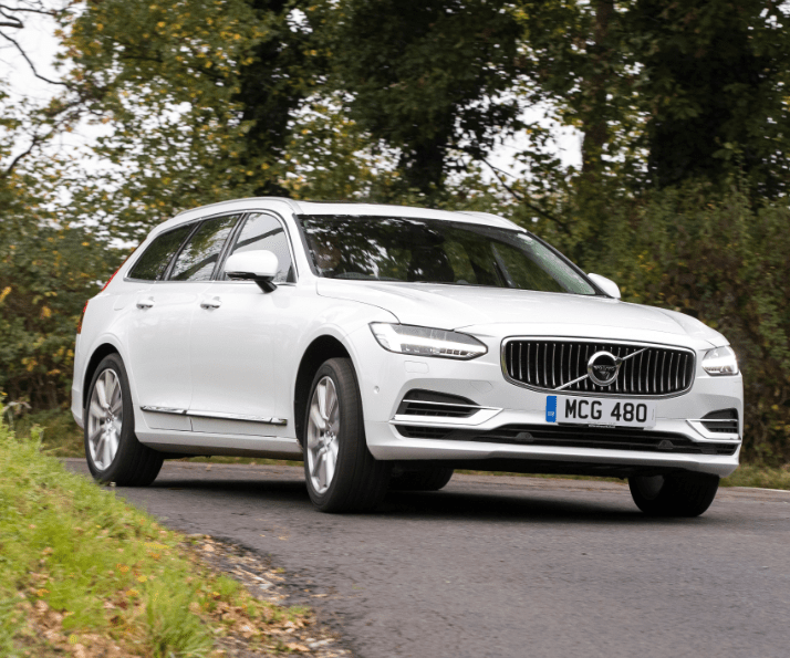 front of white volvo v90 driving down a road