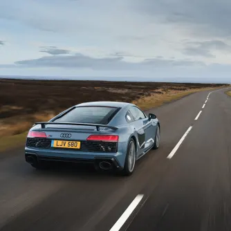 Grey Audi R8 coupe exterior rear driving down countryside road