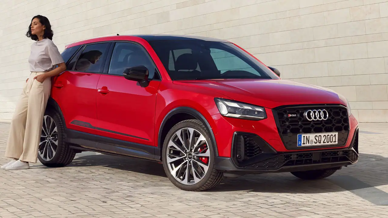 Woman leaning against a red Audi SQ2