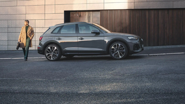 Grey Audi Q5.side view with man standing behind i
