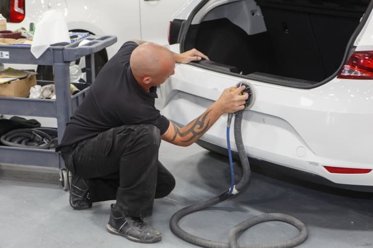 Close up of Technician working on the rear bumper of a Volkswagen Golf