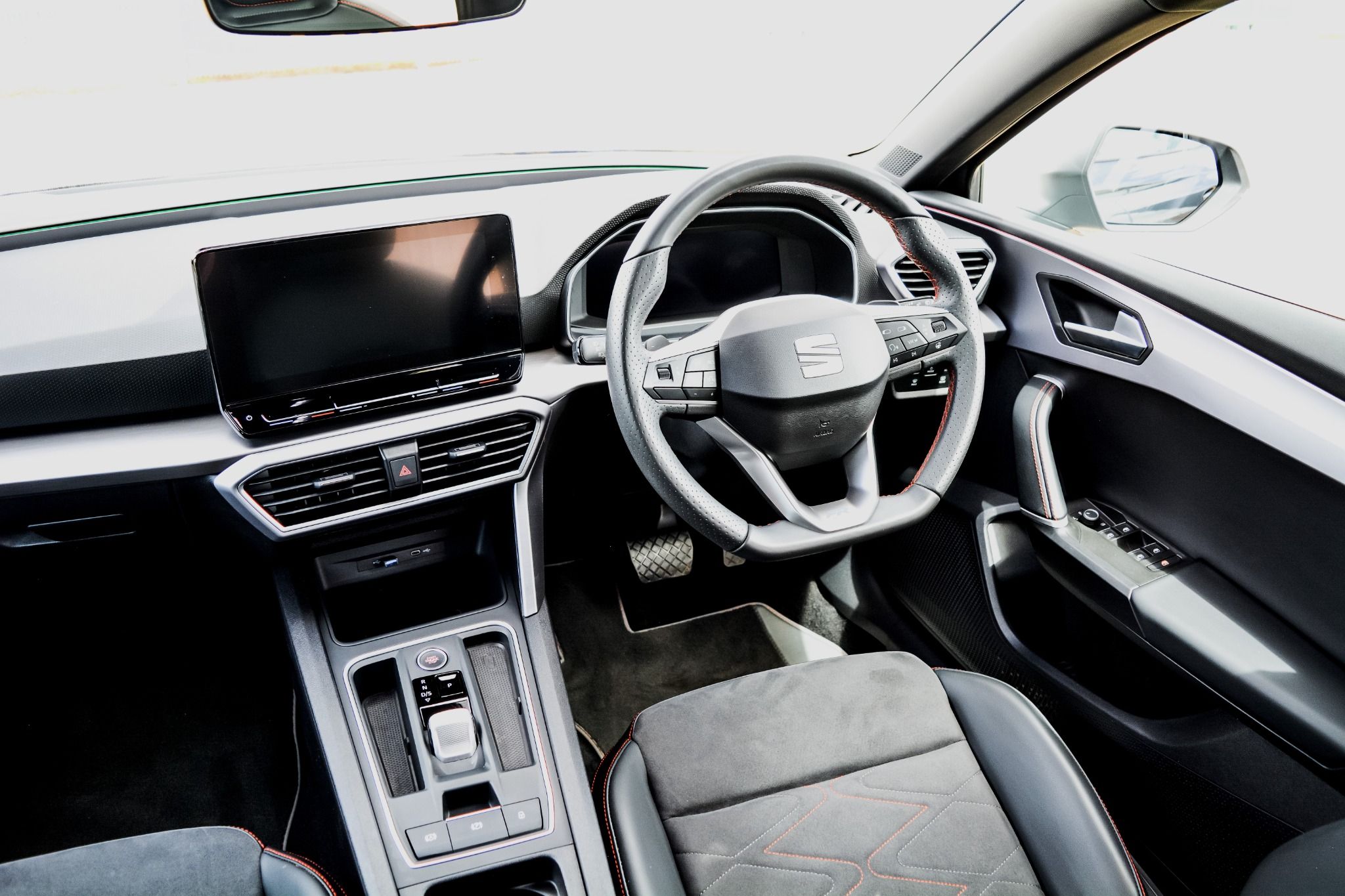 Interior view of Seat Leon showing leather black flat bottom steering wheels and entertainment system