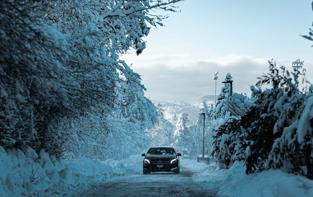 Car Driving Down Road in the Snow