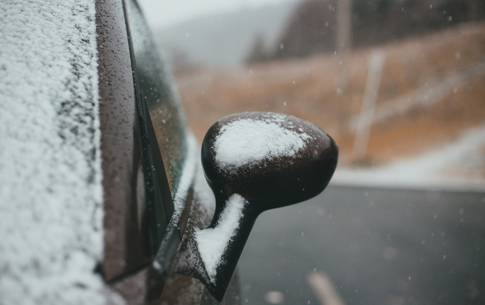 snow on a cars door mirror
