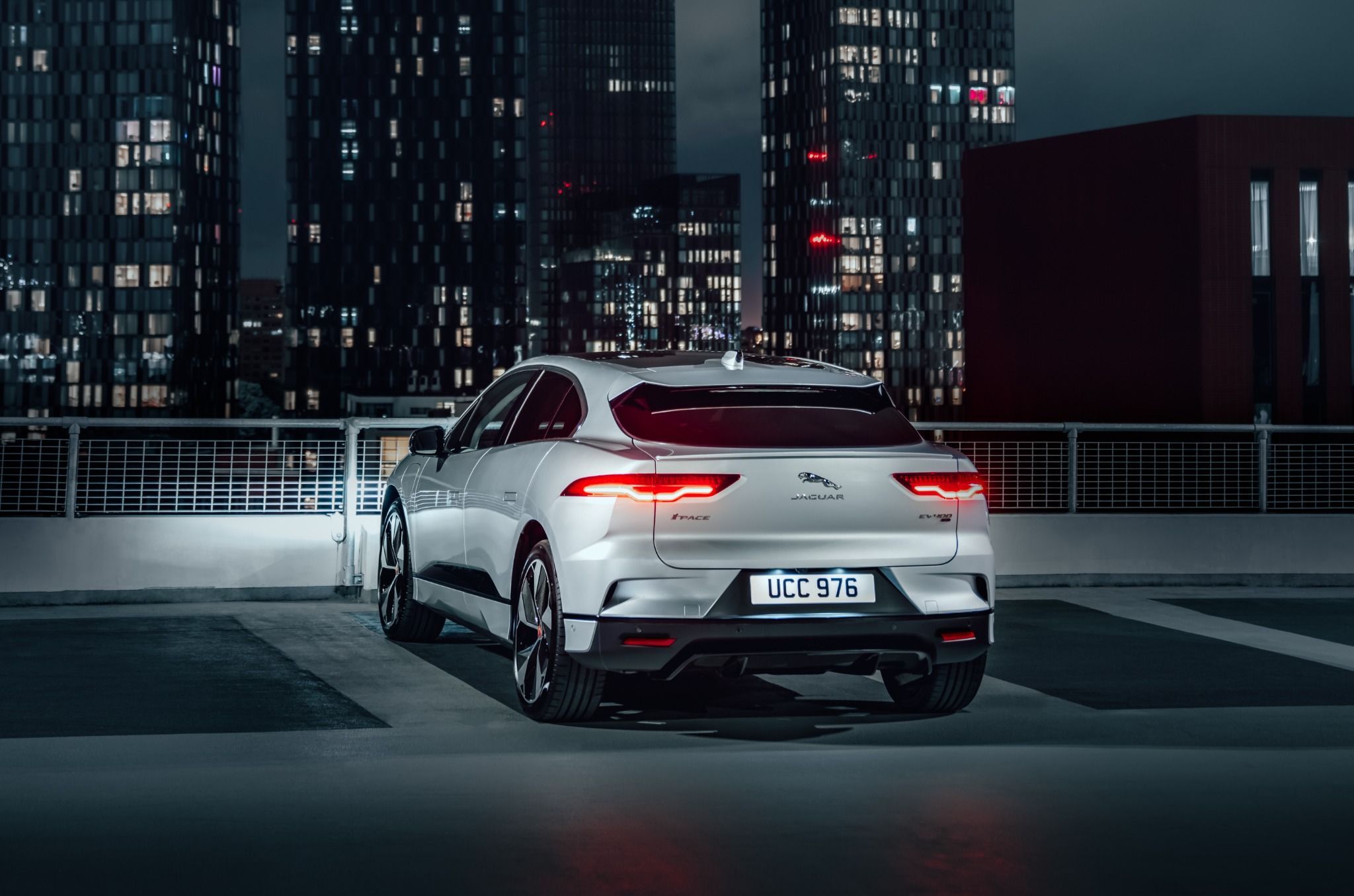 Rear view of a silver Jaguar I-Pace at night