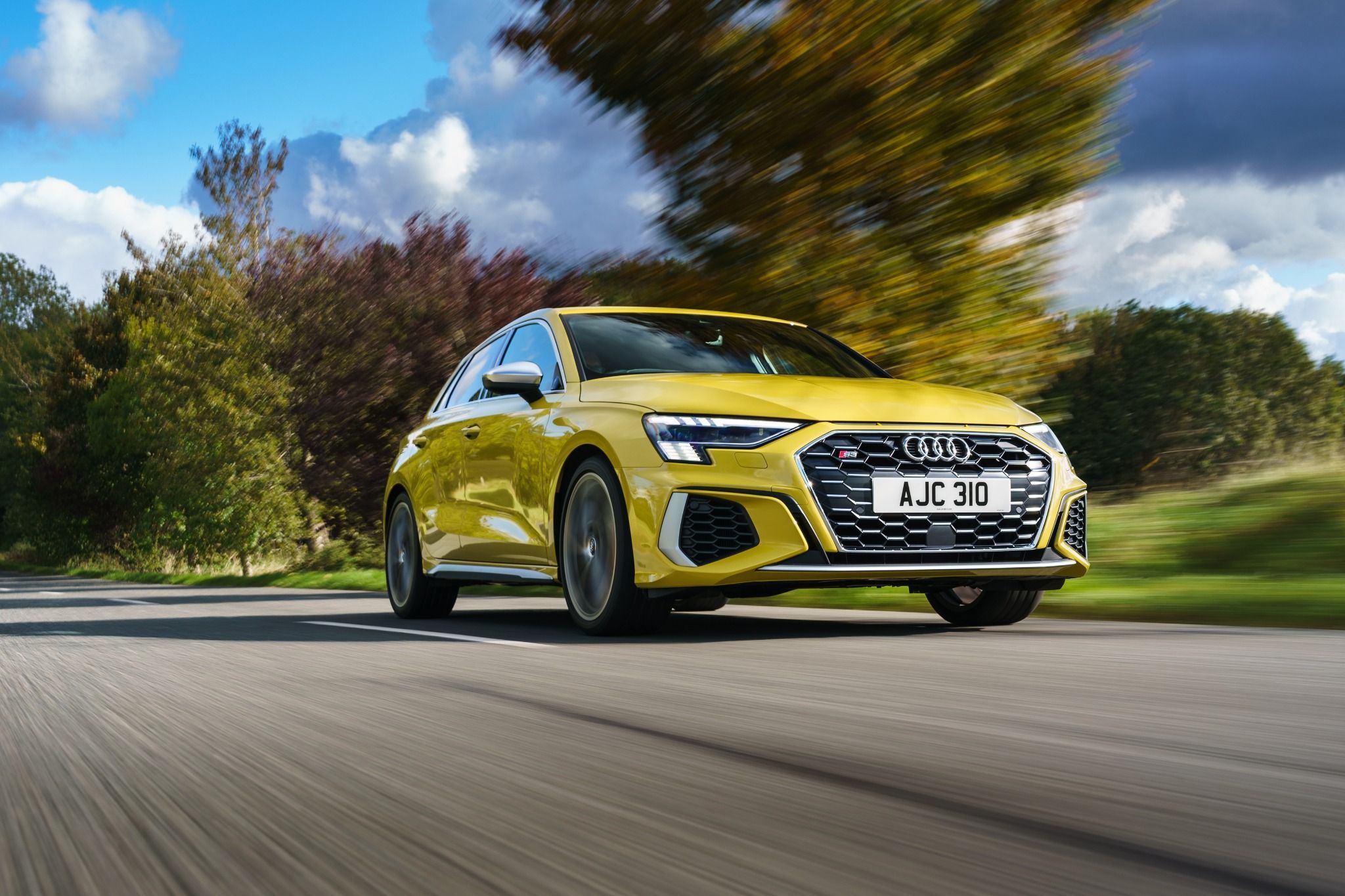 Yellow Audi S3 driving on a road
