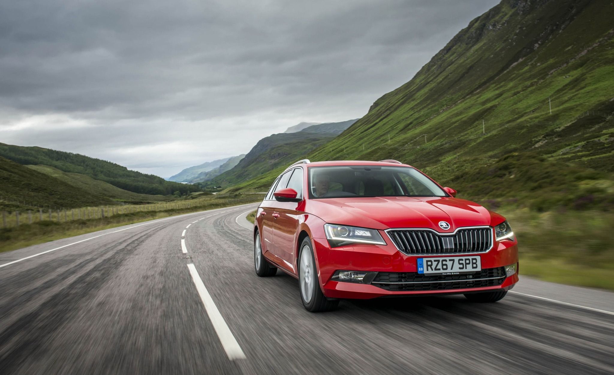 Red Skoda Superb driving on a road