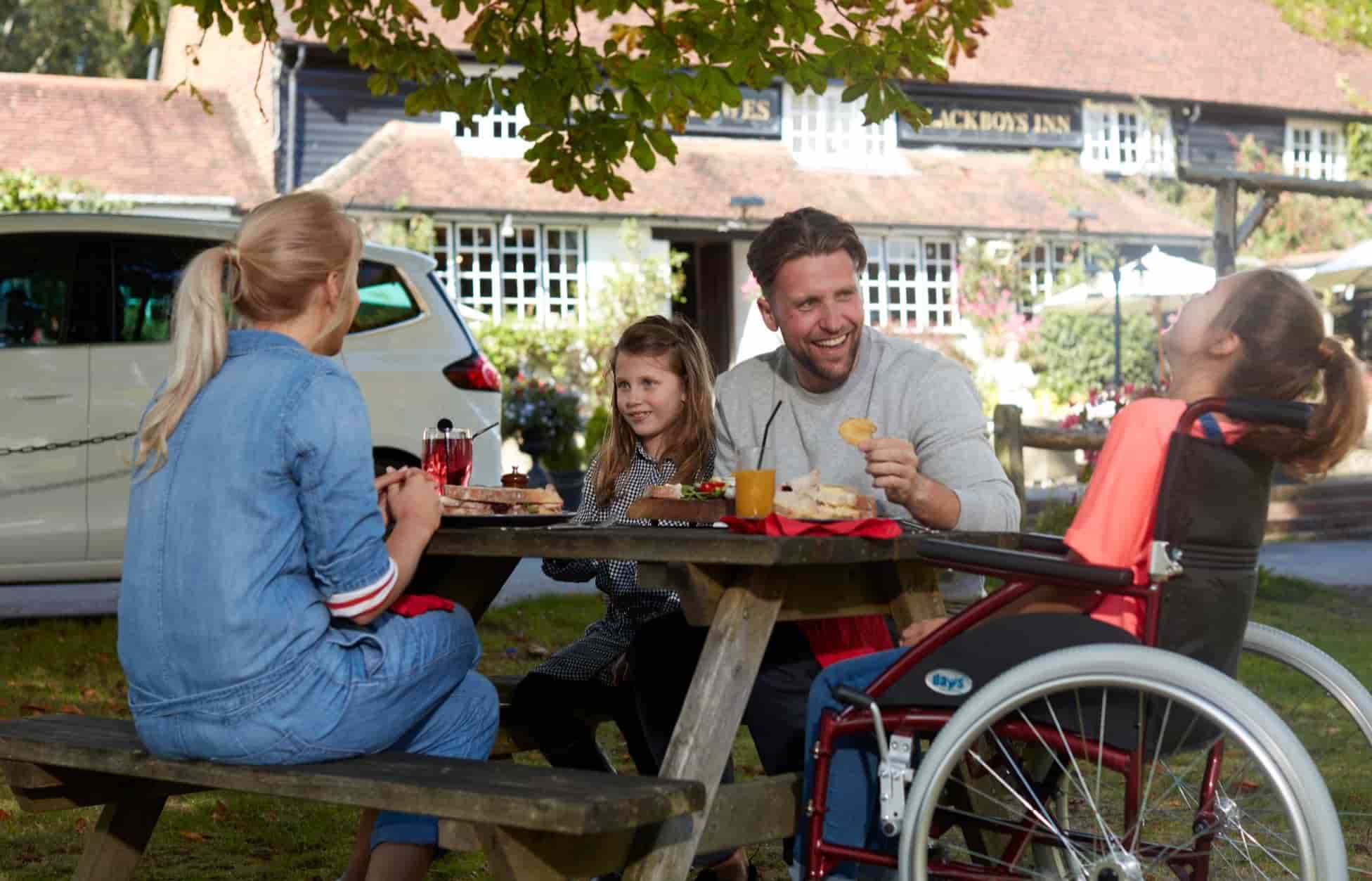 family having lunch on picnic bench
