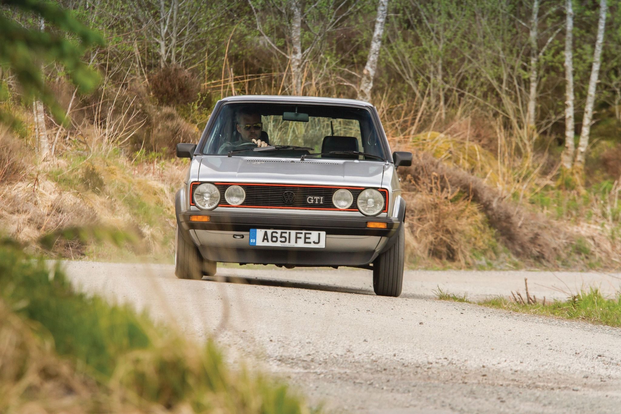Front view of an MK1 Volkswagen Golf GTI driving down the road