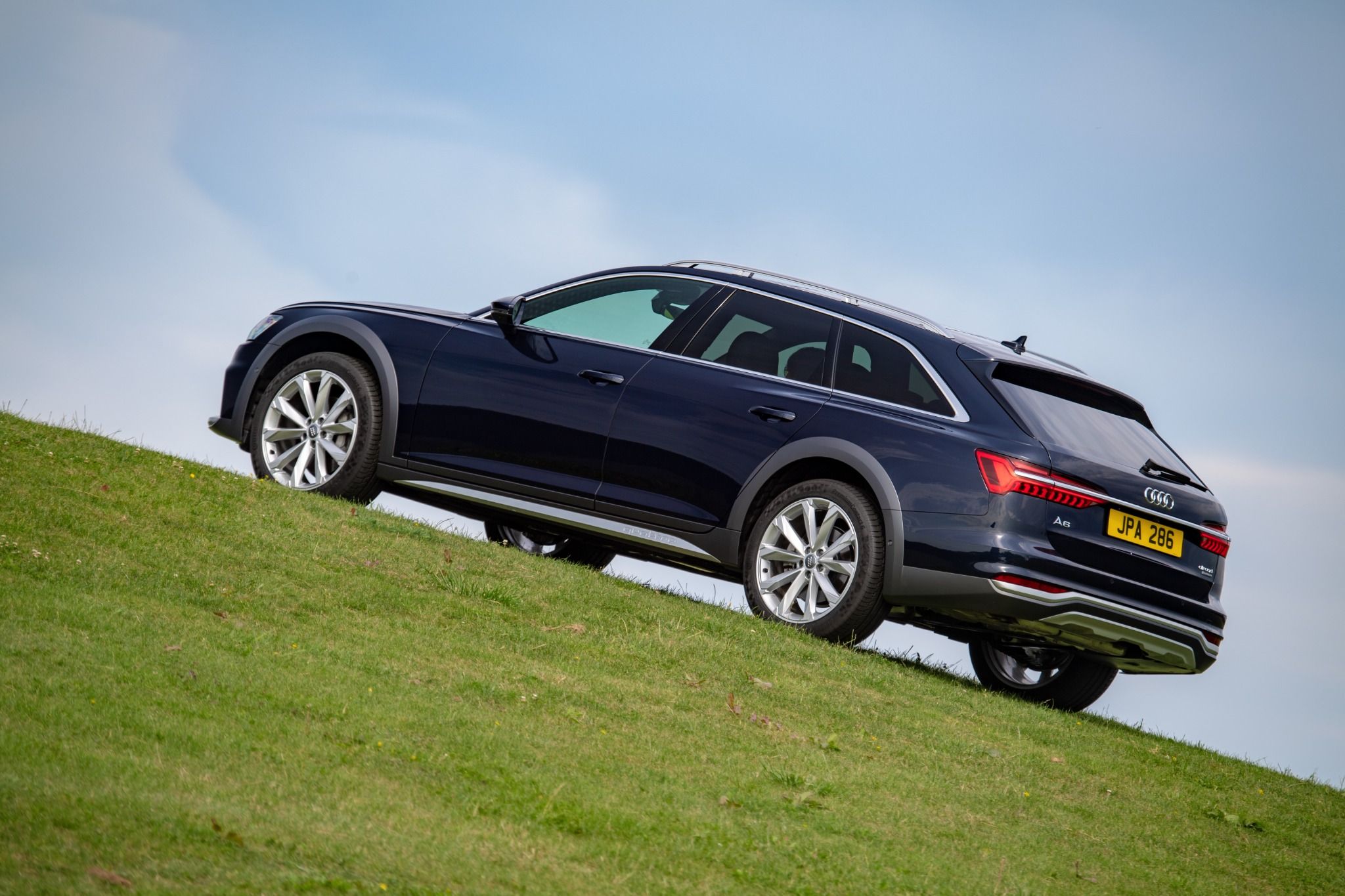 Rear view of an Audi A6 allroad driving up a hill