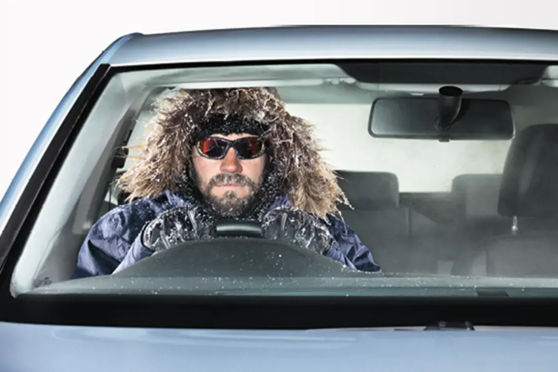 Man sitting in a car with winter clothes on