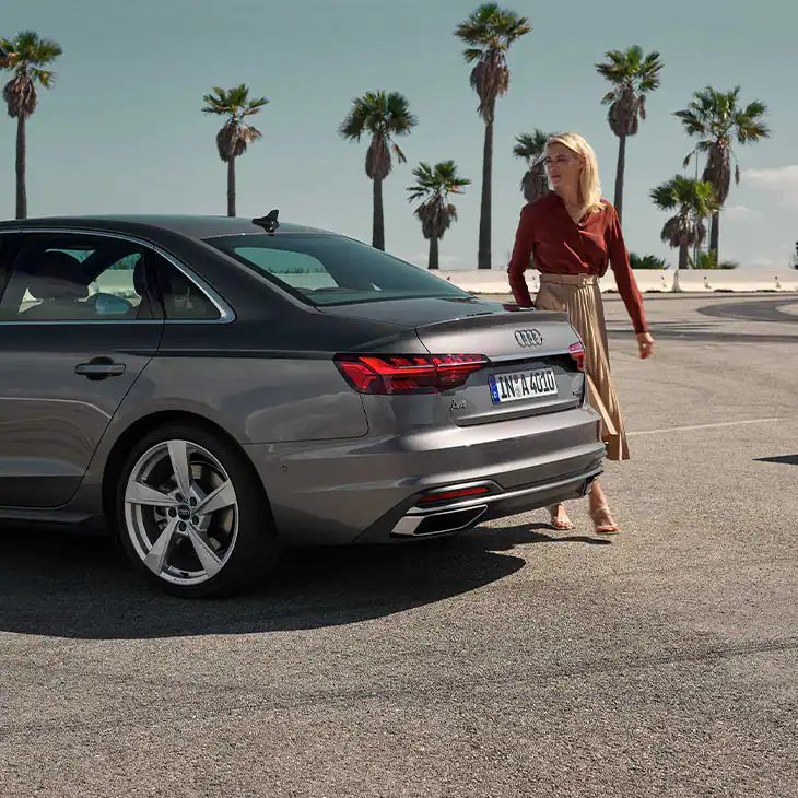 Audi A4 Saloon S Line with a women walking around the rear