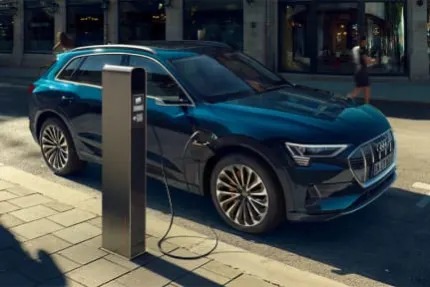Audi e-tron parked exterior side being charged