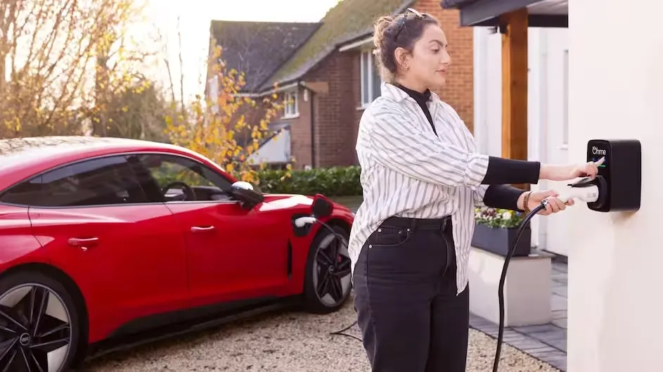 Woman plugging her Audi into an Ohme home charger