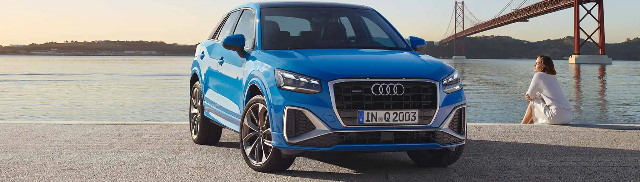 Blue Audi Q2 parked at an angle in-front of a river