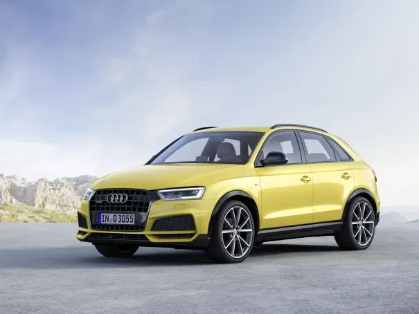 front side view of a yellow audi q3 parked up on a scenic road